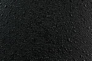 water drops on flat black rubber surface macro background photo