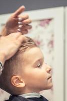 Small boy enjoying at hair salon. photo