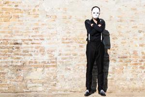 Full length of a man with mask against the wall. photo
