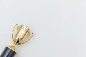 Simply flat lay design winner or champion gold trophy cup isolated on white background. Victory first place of competition. Winning or success concept. Top view copy space. photo