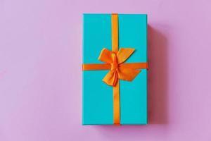 navidad año nuevo cumpleaños san valentín celebración presente concepto romántico. caja de regalo azul de diseño simplemente minimalista aislada sobre fondo violeta violeta. vista superior plana, espacio de copia foto