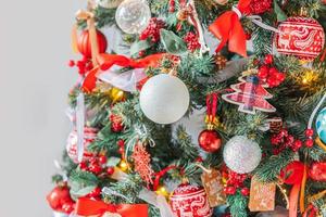 clásico árbol de año nuevo decorado con adornos rojos y blancos, juguete y pelota. apartamento de diseño de interiores de estilo clásico moderno. Nochebuena en casa. foto