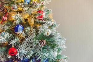 Classic Christmas decorated New year tree with red blue and white ornament toy and ball on gray wall background. Modern classical style interior design apartment. Christmas eve at home. Copy space. photo