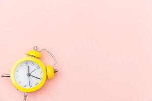 Ringing twin bell vintage classic alarm clock Isolated on pink colourful trendy pastel background. Rest hours time of life good morning night wake up awake concept. Flat lay top view copy space. photo