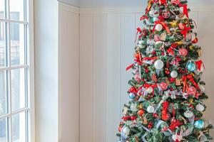 Classic Christmas New Year decorated New year tree with red and white ornament decorations toy and ball. Modern classical style interior design apartment. Christmas eve at home. photo