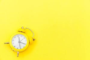 Ringing twin bell vintage classic alarm clock Isolated on yellow colourful trendy modern background. Rest hours time of life good morning night wake up awake concept. Flat lay top view copy space. photo