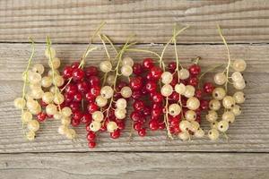 Large berries currant red and white on a branch against the background of an grey board. photo