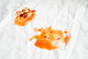 Dirty tomato sauce stain or ketchup on cloth to wash with washing powder, cleaning housework concept. photo