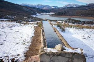 abrevadero junto a un lago en las montañas nevadas foto