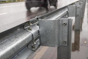 Tornillos y tuercas atornillados en la barandilla de la carretera foto