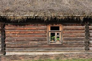 fondo de fotograma completo y textura de la casa de troncos rusa tradicional con techo de paja y una ventana foto