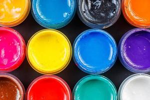 full-frame close-up background of opened small gouache paint jars photo