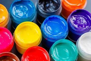 full-frame close-up background of opened small gouache paint jars photo