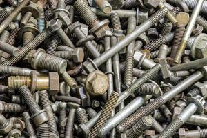 full frame background of used automobile bolts heap, old and dirty photo