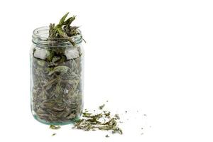 glass jar of dryed natural mint leaves isolated on white background photo