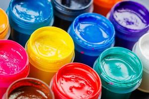 full-frame close-up background of opened small gouache paint jars photo