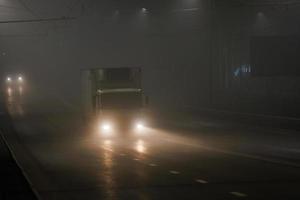 small hoodless dry van truck moving on night foggy road photo