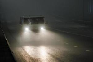 small soviet minivan car moving on night foggy road photo