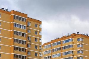 nuevos edificios de apartamentos de ladrillo amarillo-naranja de gran altura a la luz del día nublado, vista de teleobjetivo de primer plano foto