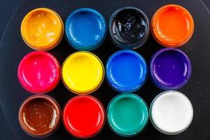 full-frame close-up background of opened small gouache paint jars photo