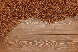 roasted coffee beans laid on brown wooden table surface photo