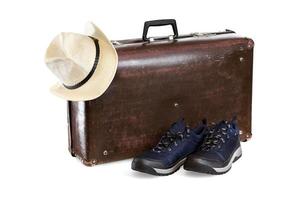 old brown fiber suitcase with hat and sneakers isolated on white background photo