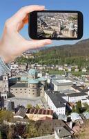 turista tomando fotos de la ciudad de salzburgo, austria