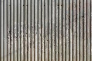 corrugated zinc-plated sheet fence with paper advertisements leftovers photo