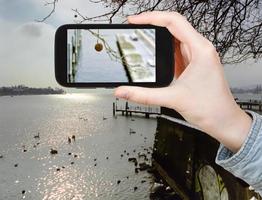 turista tomando fotos del lago de ginebra en invierno