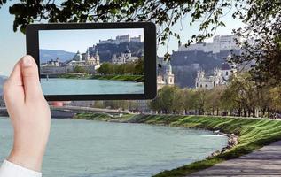 turista tomando fotos del río salzach y salzburg