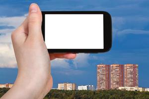 smartphone and dark blue sky over urban houses photo