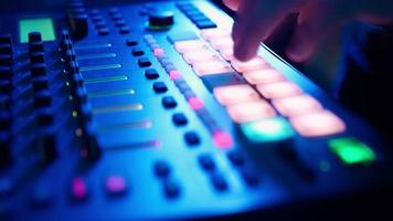 Professional DJ Plays a Beat Sampler with Color Drum Pads and Samples in Studio Environment. Beatmaker Plays edm Tracks on Party in a Nightclub. Electronic Musical Instrument. Unrecognizable person