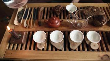 Traditional Tea Making on a Board for a Tea Ceremony by Candlelight with Soft Day Lighting. Man Pours Boiling Water into a Teapot. Top View. Unrecognizable person. video