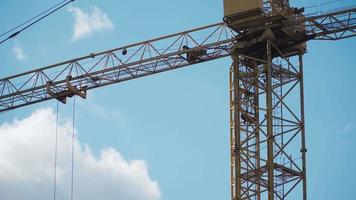 Big industrial construction crane with beautiful cloudy sky background. City development video