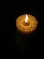A wax candle burning in the dark photo