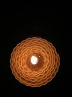 A wax candle burning in the dark photo