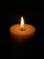 A wax candle burning in the dark photo