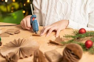 la niña hace decoraciones para árboles de navidad con papel con sus propias manos. paso 3. instrucción paso a paso foto