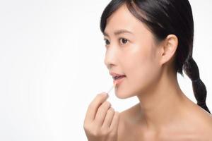 Portrait young asian woman looking mirror applying makeup lipstick at room photo