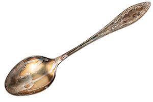 old cupronickel spoon with visible oxidation layer isolated on white background photo