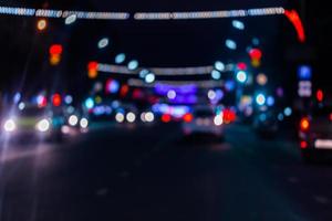 Defocused picture of night street car traffic - view from road. Colorful night life background. photo