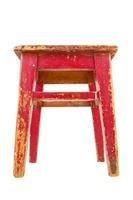 Old wooden stool with peeling red paint. Loft style chair isolated on a white background. photo