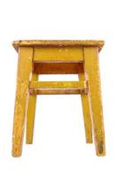 Old wooden stool with yellow peeling paint. Loft style chair isolated on a white background. photo