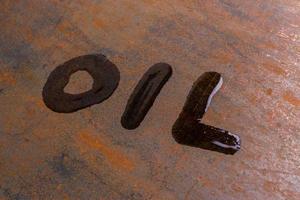 handwritten word oil on rusted sheet metal surface - close-up photo