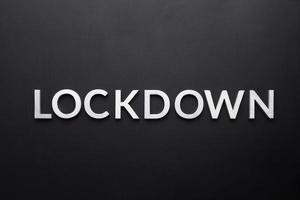 the word lockdown laid with silver metal letters on flat black background in directly above perspective photo