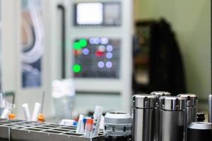 A set of shiny collet chucks in metalworking shop with blurry cnc milling machine inn the background. photo