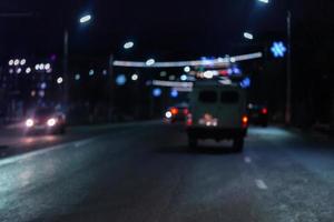 Defocused picture of night street car traffic - view from road. Colorful night life background. photo