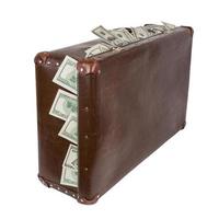 An old closed brown suitcase with sticking out dollar banknotes. Standing up and isolated on white background. photo