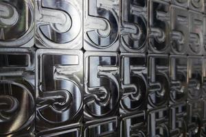 shiny metal machined digit 5 plates tiled tightly - full frame background photo