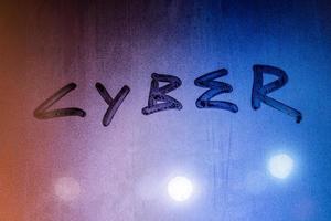 the word cyber handwritten on night wet glass surface photo